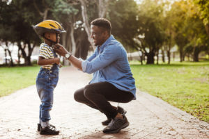 Dad adjusting bike helmet