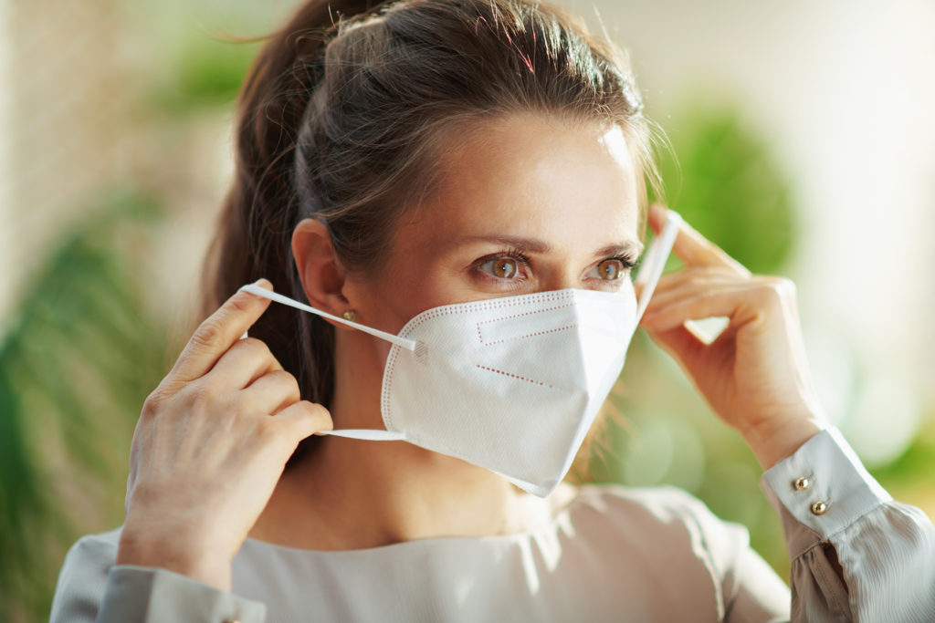 Woman puts on N95 mask