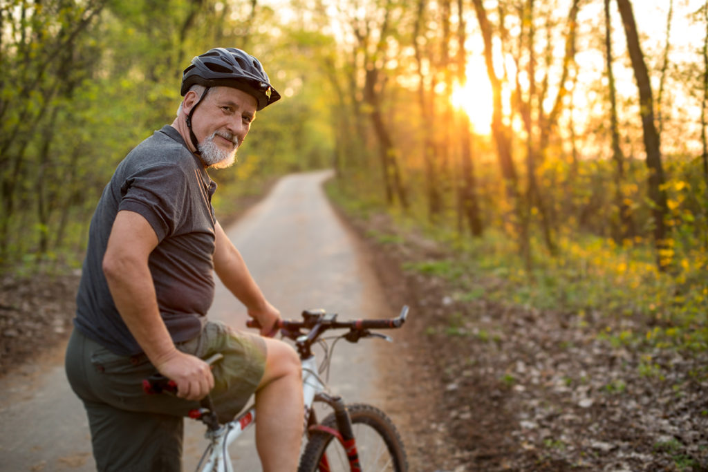Senior man on trail stops bike