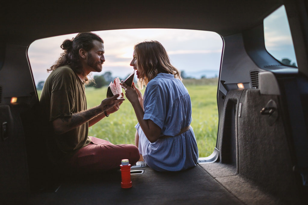 Happy couple having a snack by the side of the road