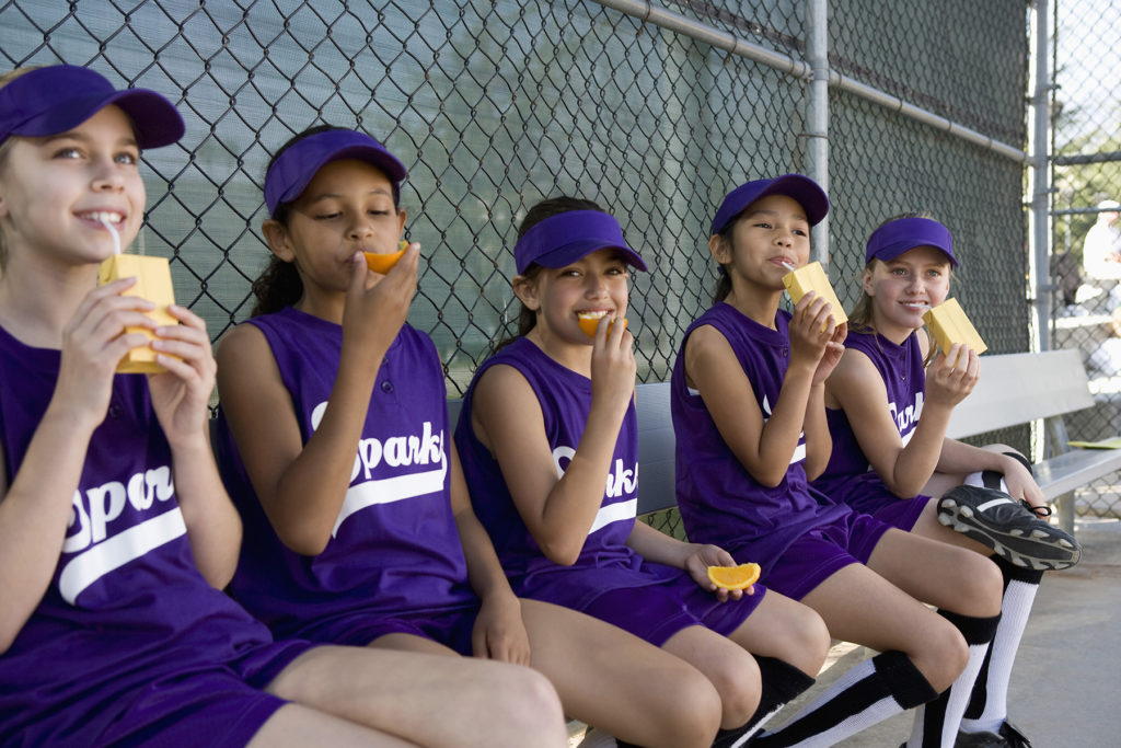 dugout shot of girls' team eating fruit