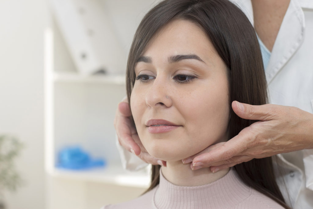 Female getting thyroid exam