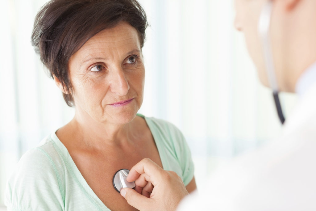 Doctor checks woman's heart rate