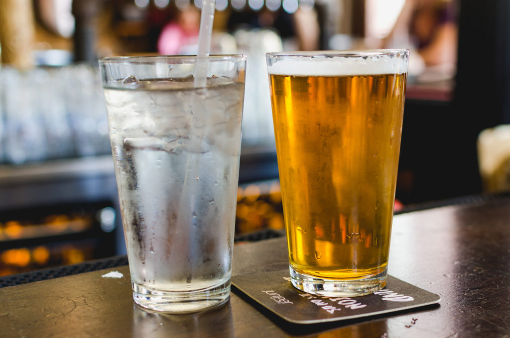 Beer and water on a bar