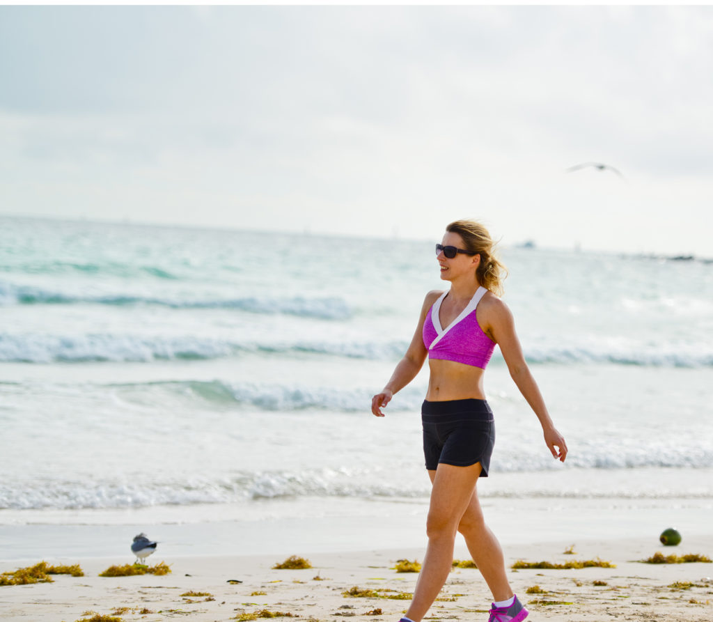 Woman walks on beach for exercise