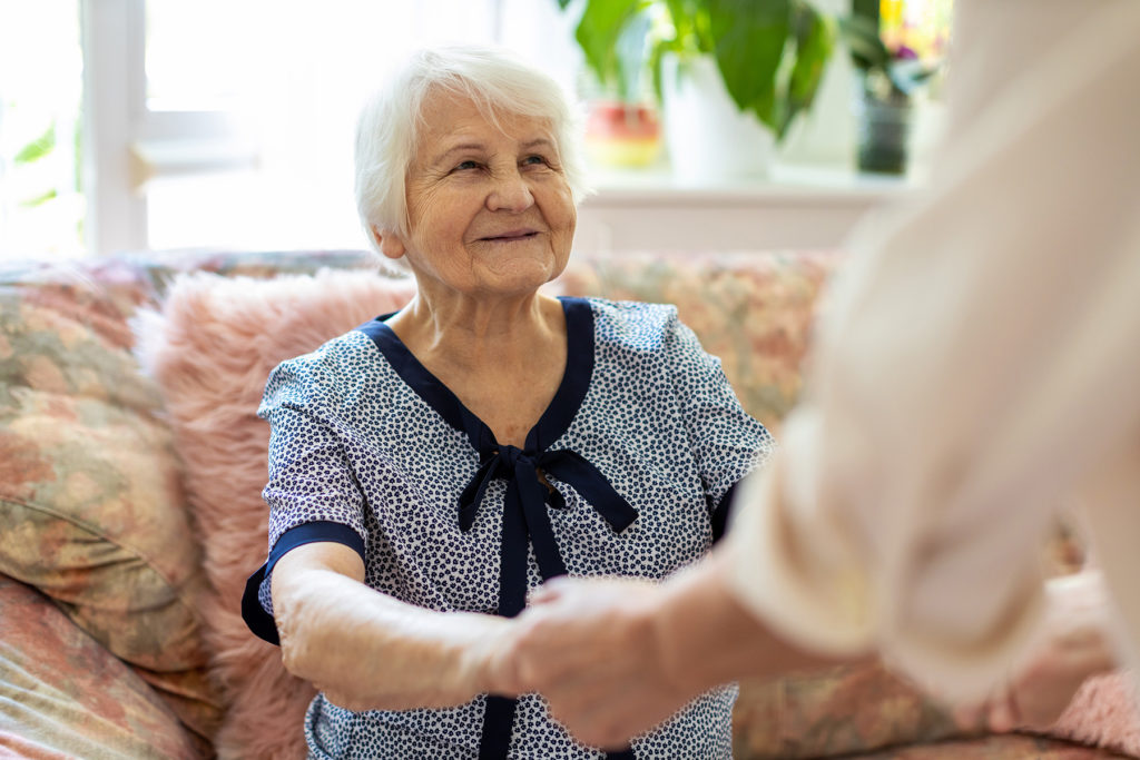 Senior woman looks appreciatively at caretaker