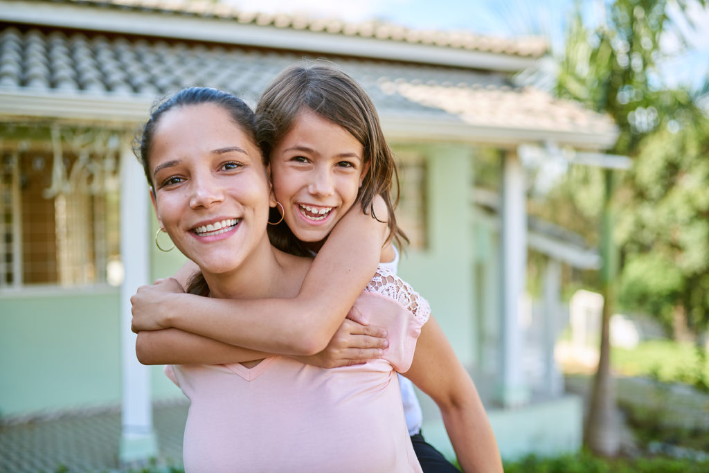Mom gives daughter piggy back ride