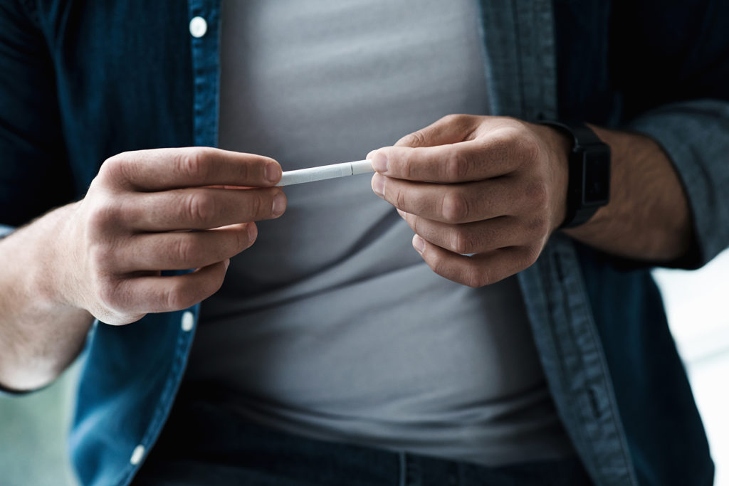 Man holds cigarette
