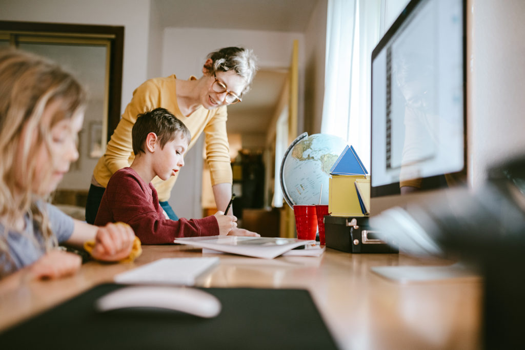 Mother looks over kids studying at home