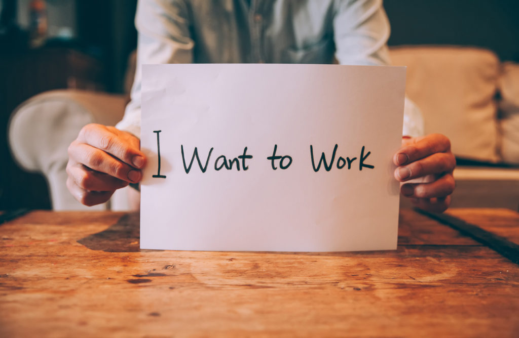 Man holding I want to work sign