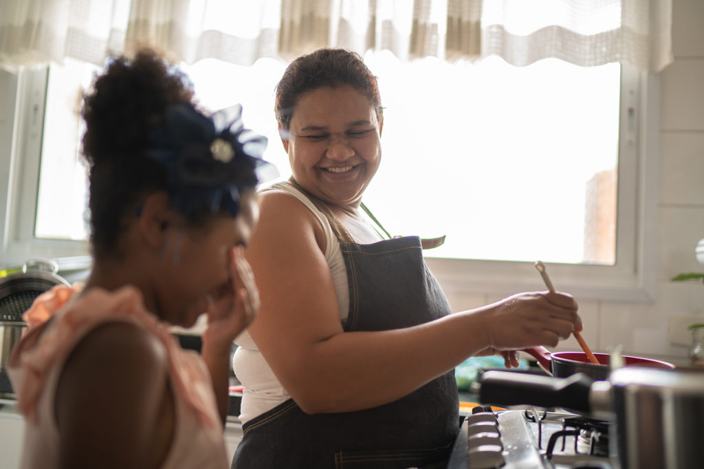 Mom and young girl cooking together