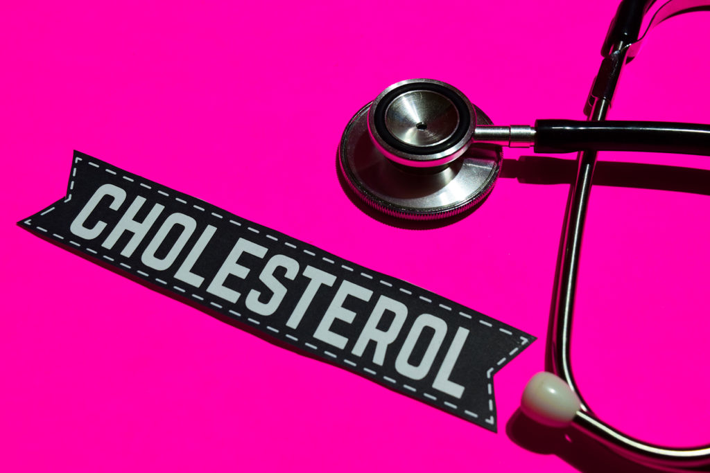 stethoscope and cholesterol on pink background