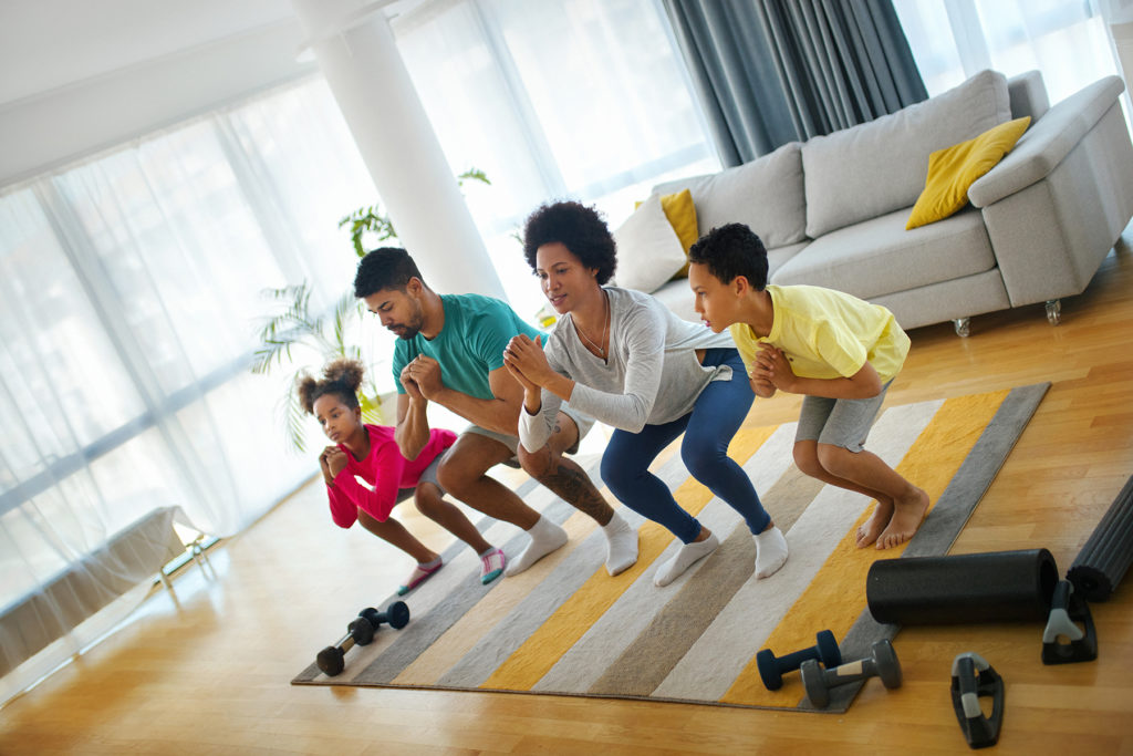 Black family doing yoga in living room