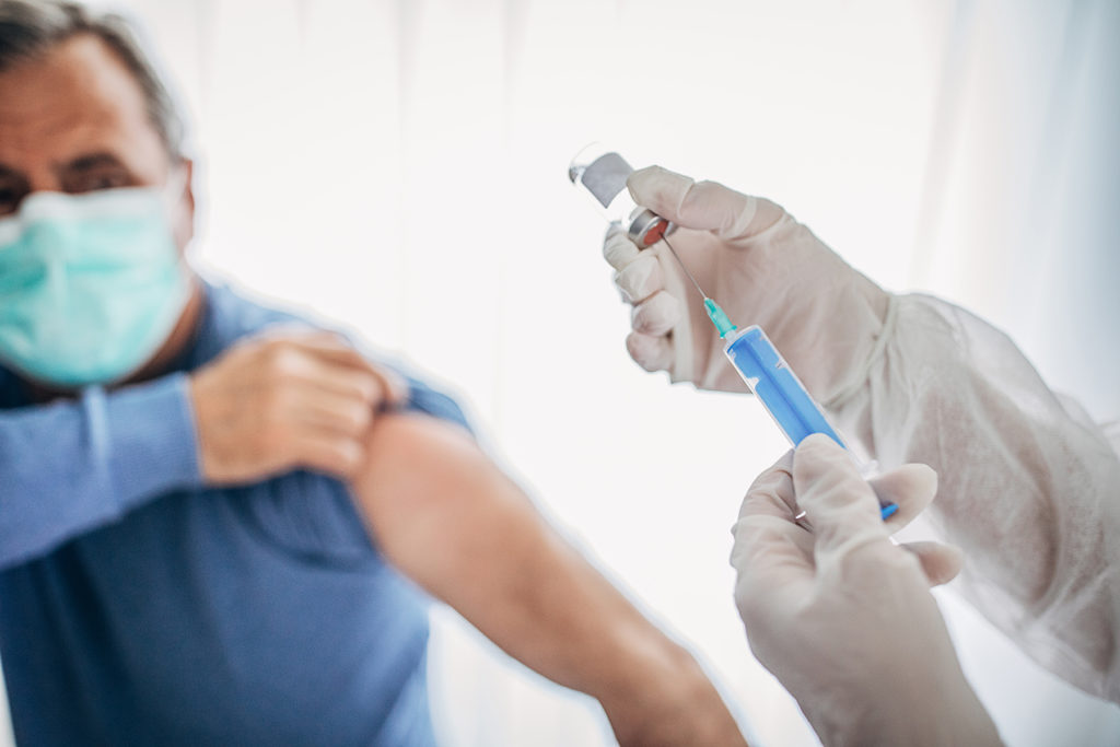 Senior male gets Covid-19 vaccine