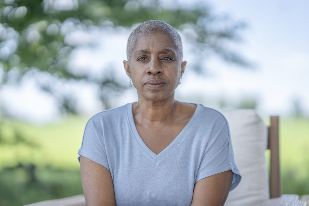 An African American woman sits outside