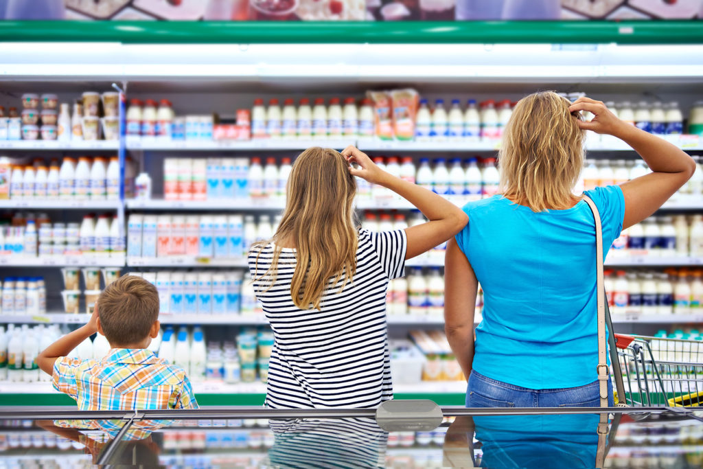 Family choosing between products in grocery aisle