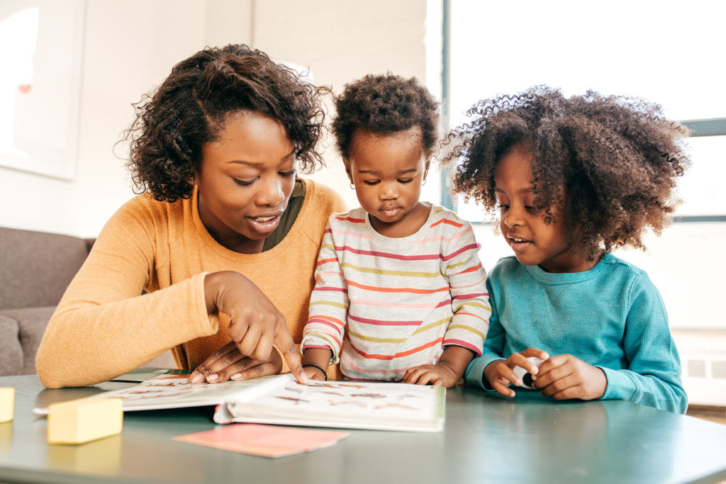 Black mom reading with her two children