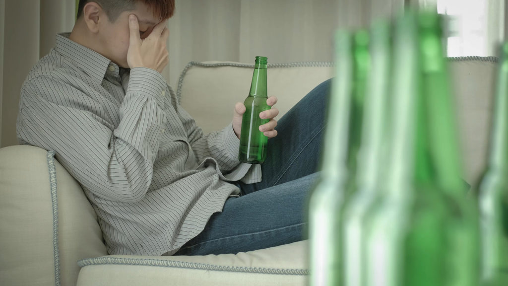 man sittinng on couch after too many beers