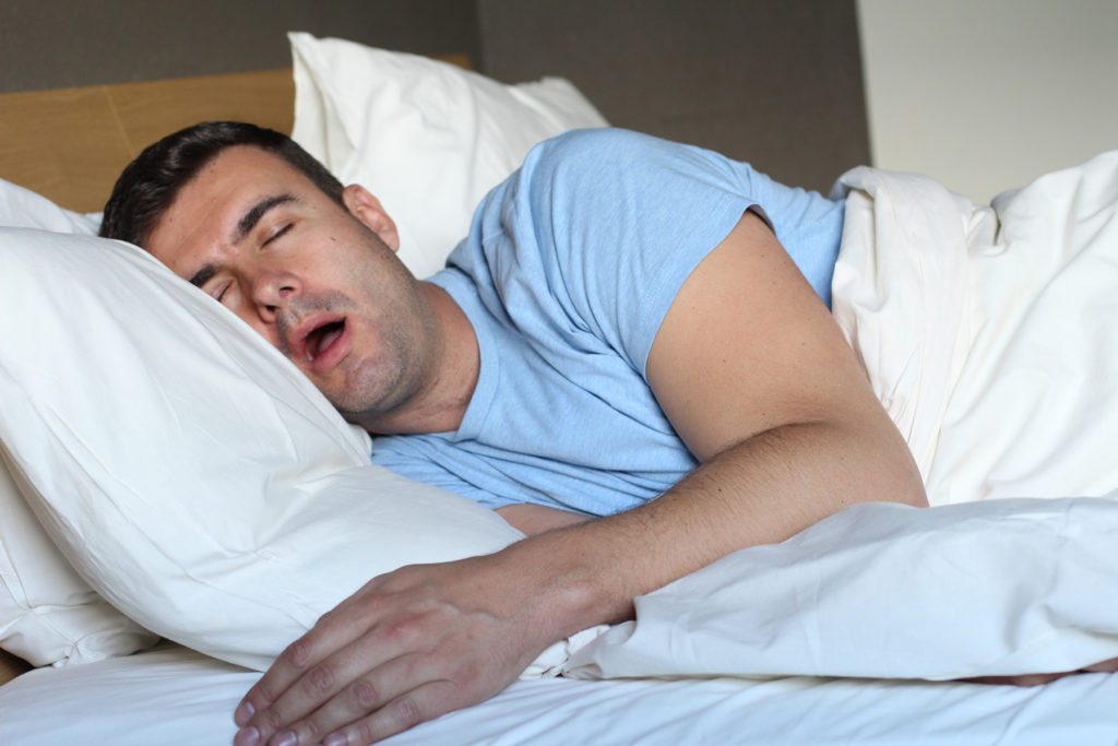man in bed snoring