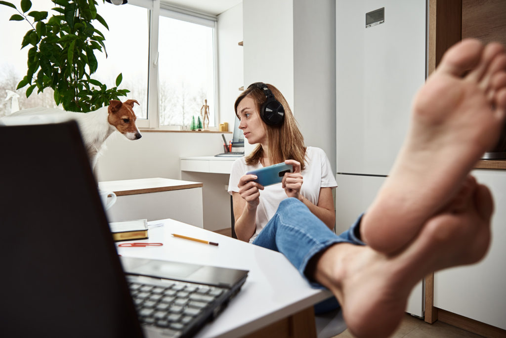 Woman at desk with phone procrastinating