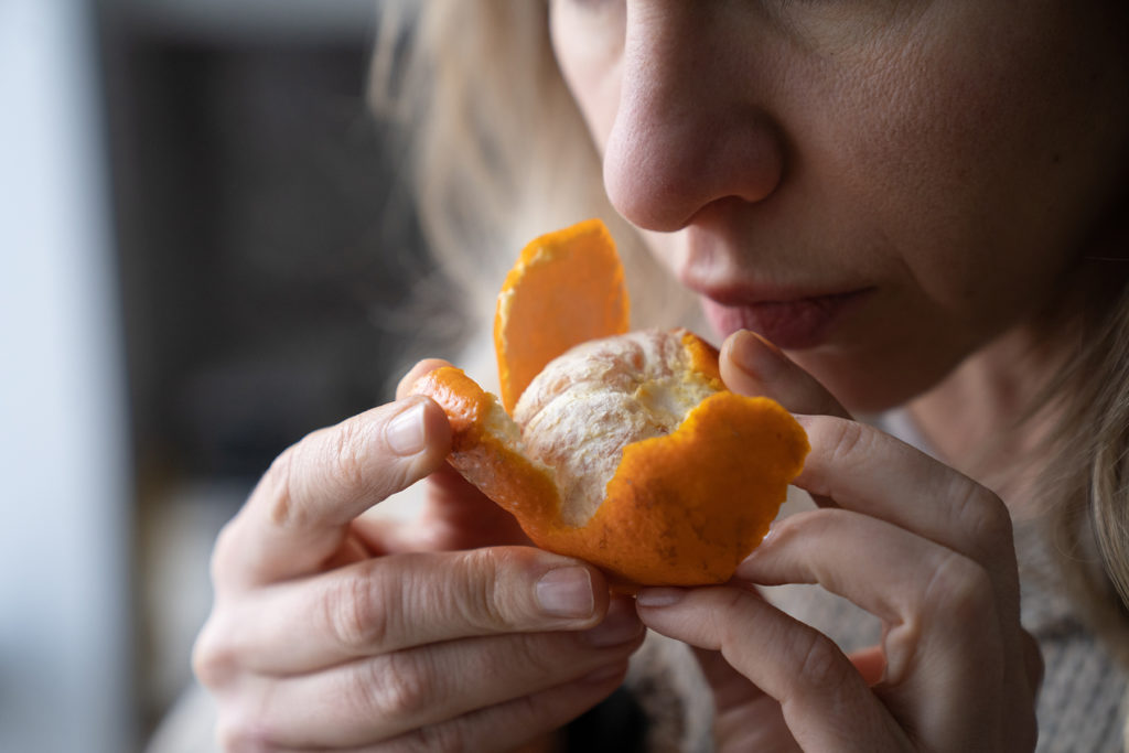 woman trying to smell an orange