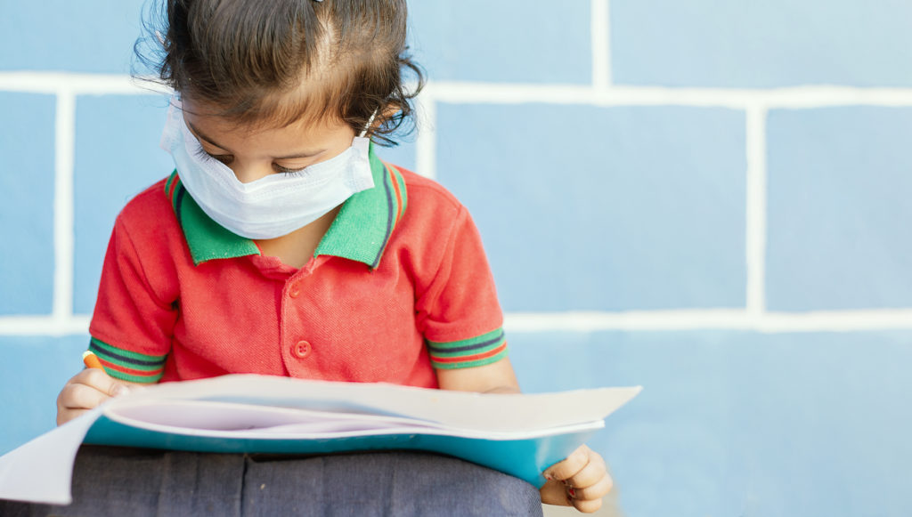 Girl reading wearing COVID mask