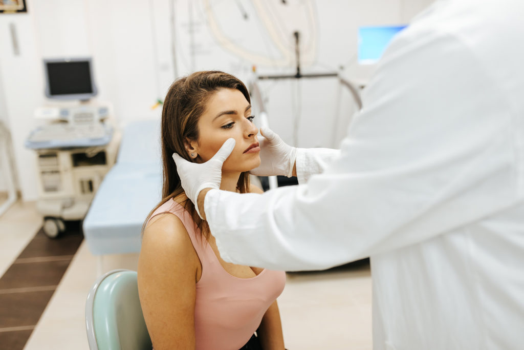 Doctor inspecting woman's face