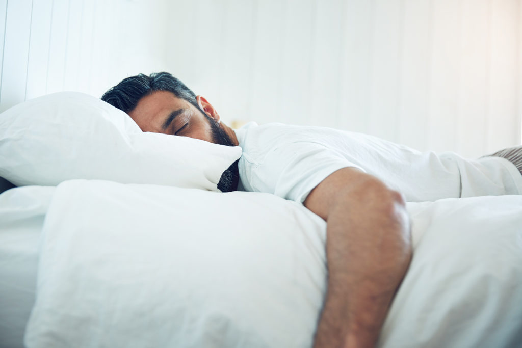 man takes a nap, white sheets